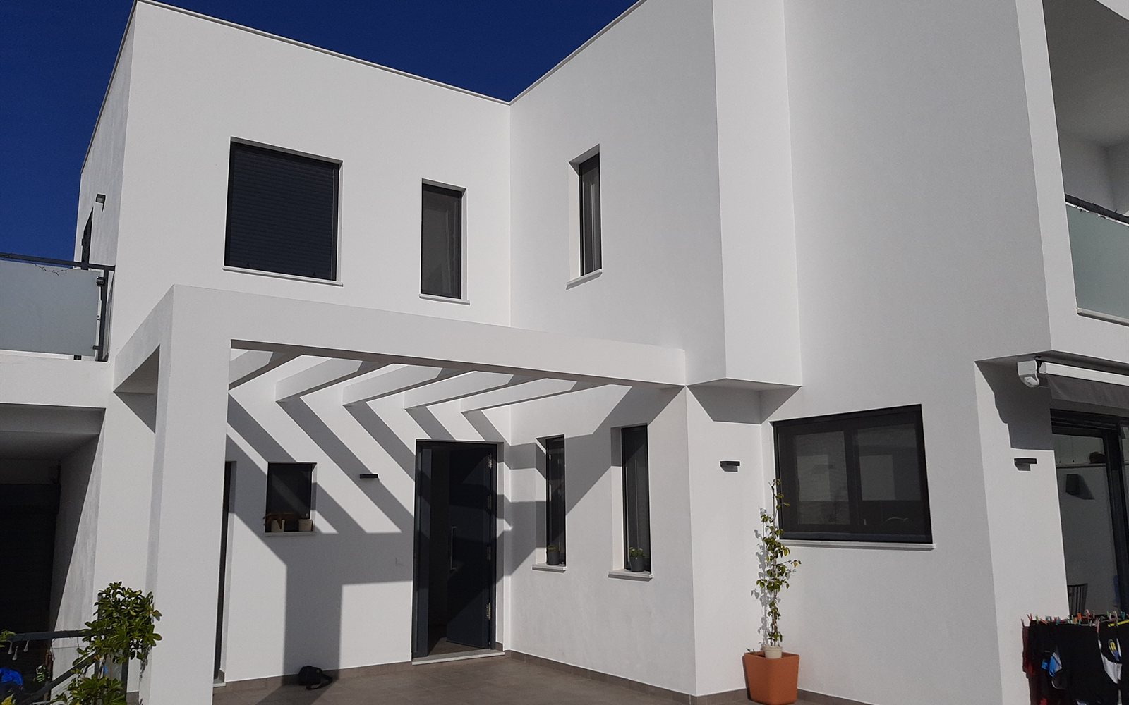 Patio de vivienda unifamiliar con pérgola de lamas proyectada por CAC Arquitectos