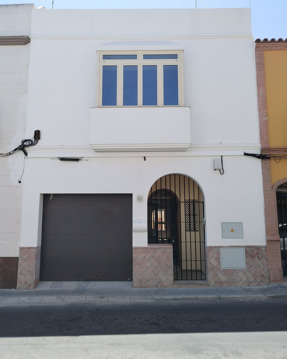 Fachada encalada con recercados de una vivienda entre medianeras proyectada por CAC Arquitectos